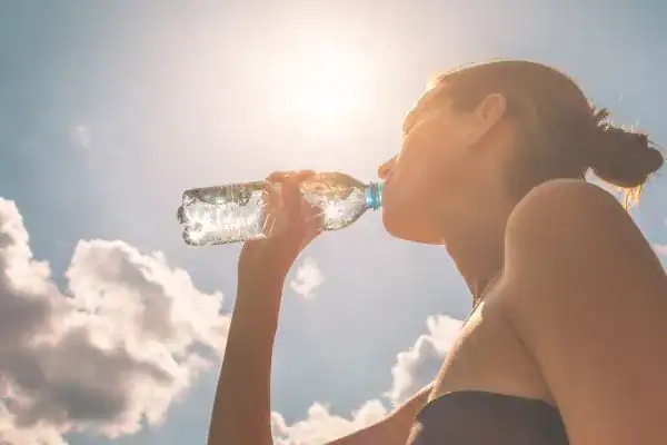 Hydration: The Secret Ingredient for a Toned Stomach and Enhanced Fitness 3 Image of woman drinking water to hydrate Brighton after run.